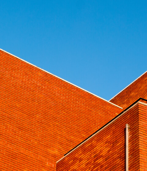Exterior walls and roofline of a commercial brick building.