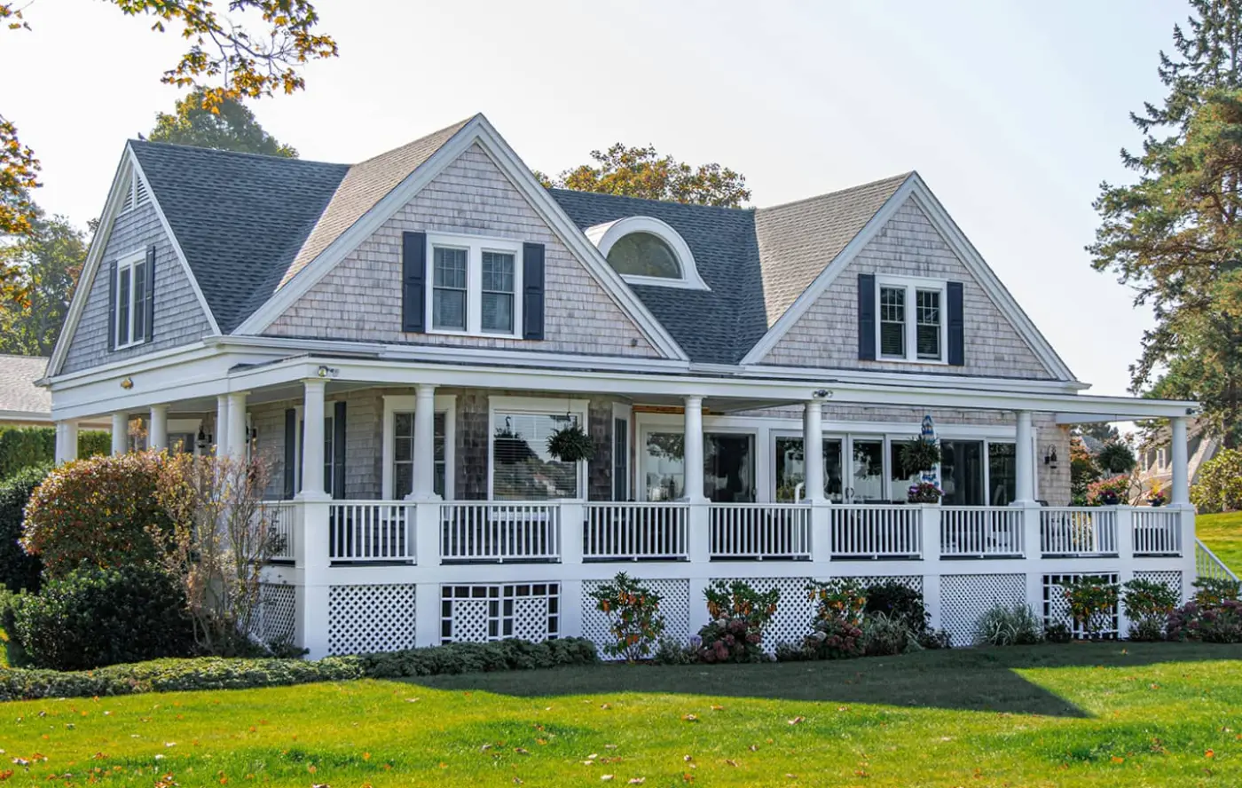 Traditional two-story house with a covered front porch and dormer windows.